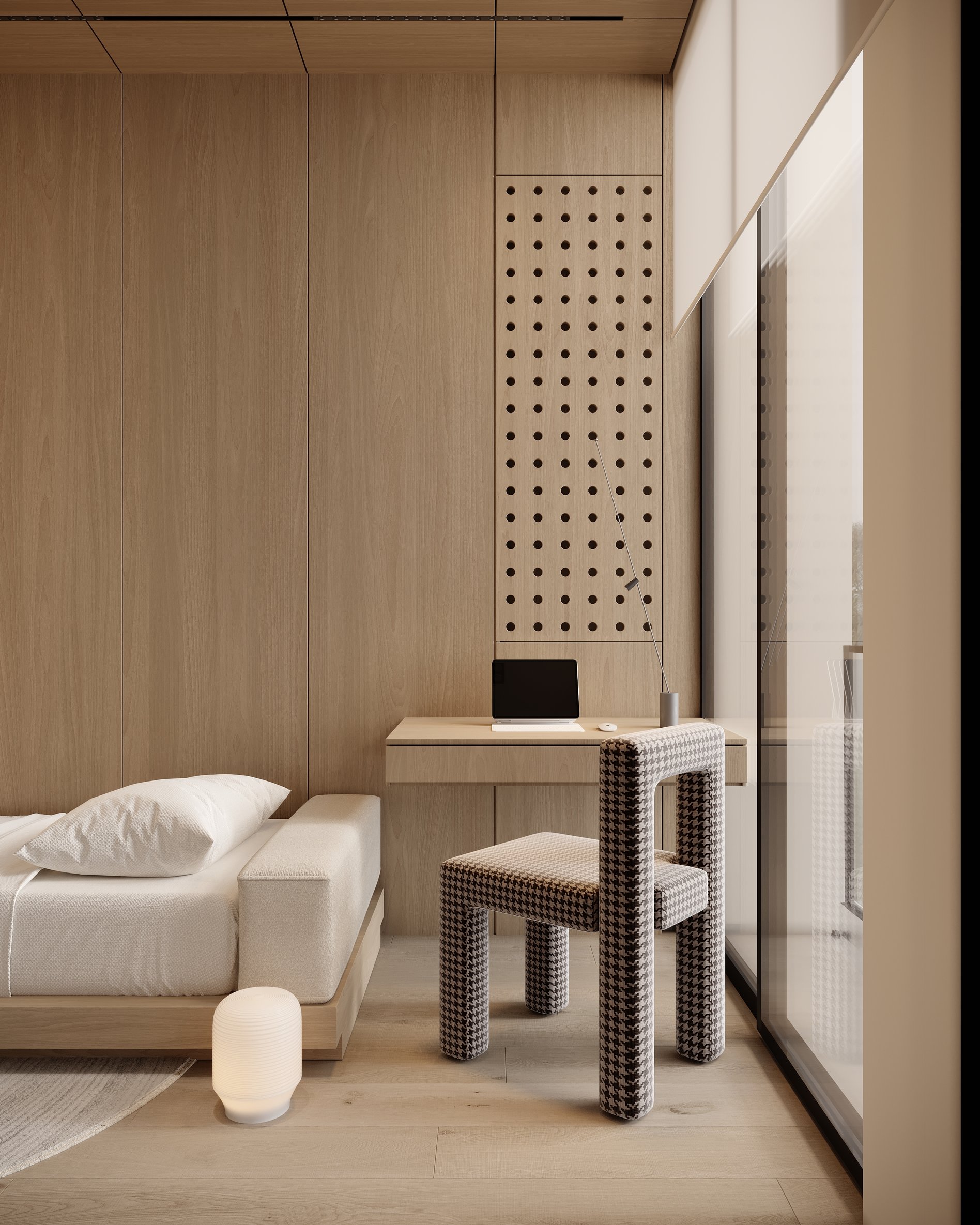 Guest bedroom study area with perforated wooden wall panels, floating desk, and designer houndstooth chair with table lamp.