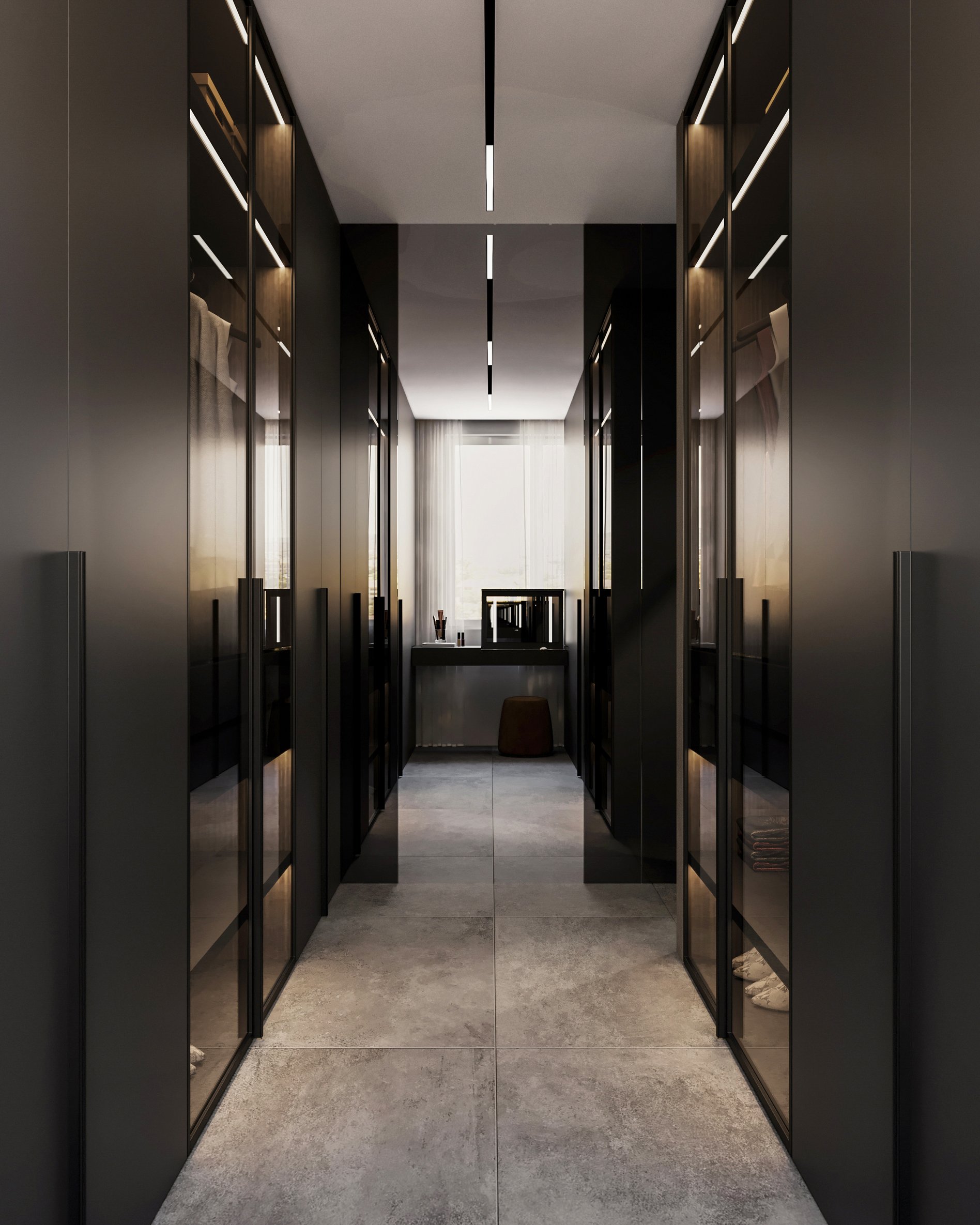 Luxurious walk-in closet with black glass wardrobes, integrated LED lighting, and concrete flooring leading to a vanity area.