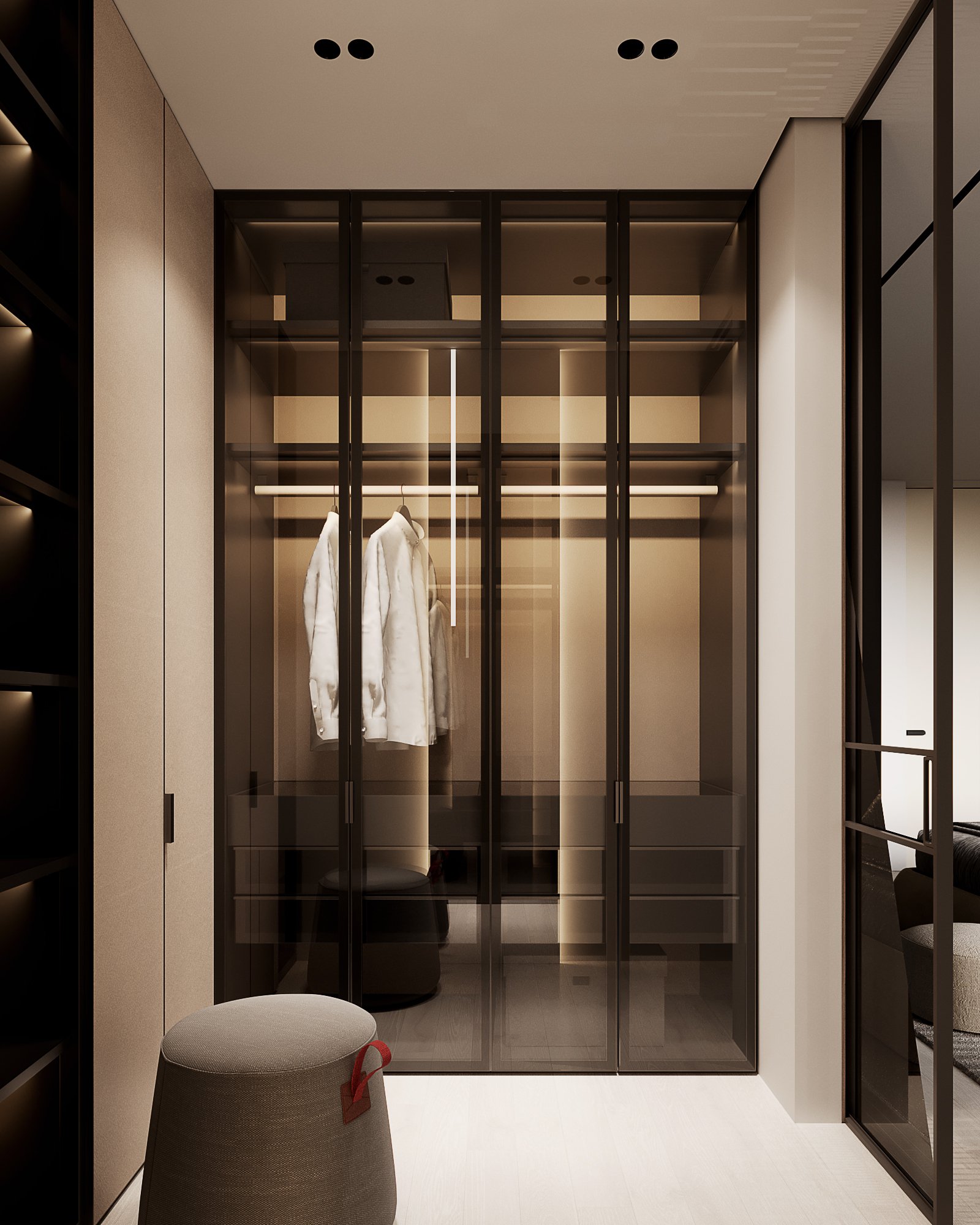 Modern walk-in closet with smoked glass doors, LED lighting, and grey ottoman featuring built-in illuminated shelving.