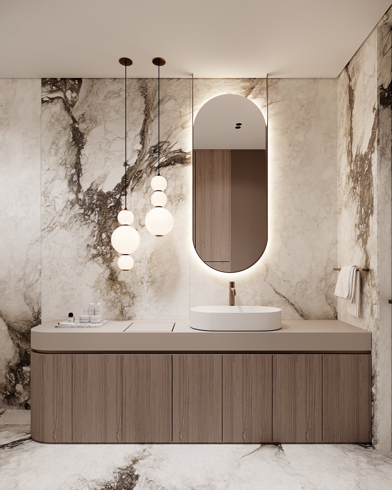 Luxury bathroom vanity with oval backlit mirror, spherical pendant lights and dramatic marble wall cladding.