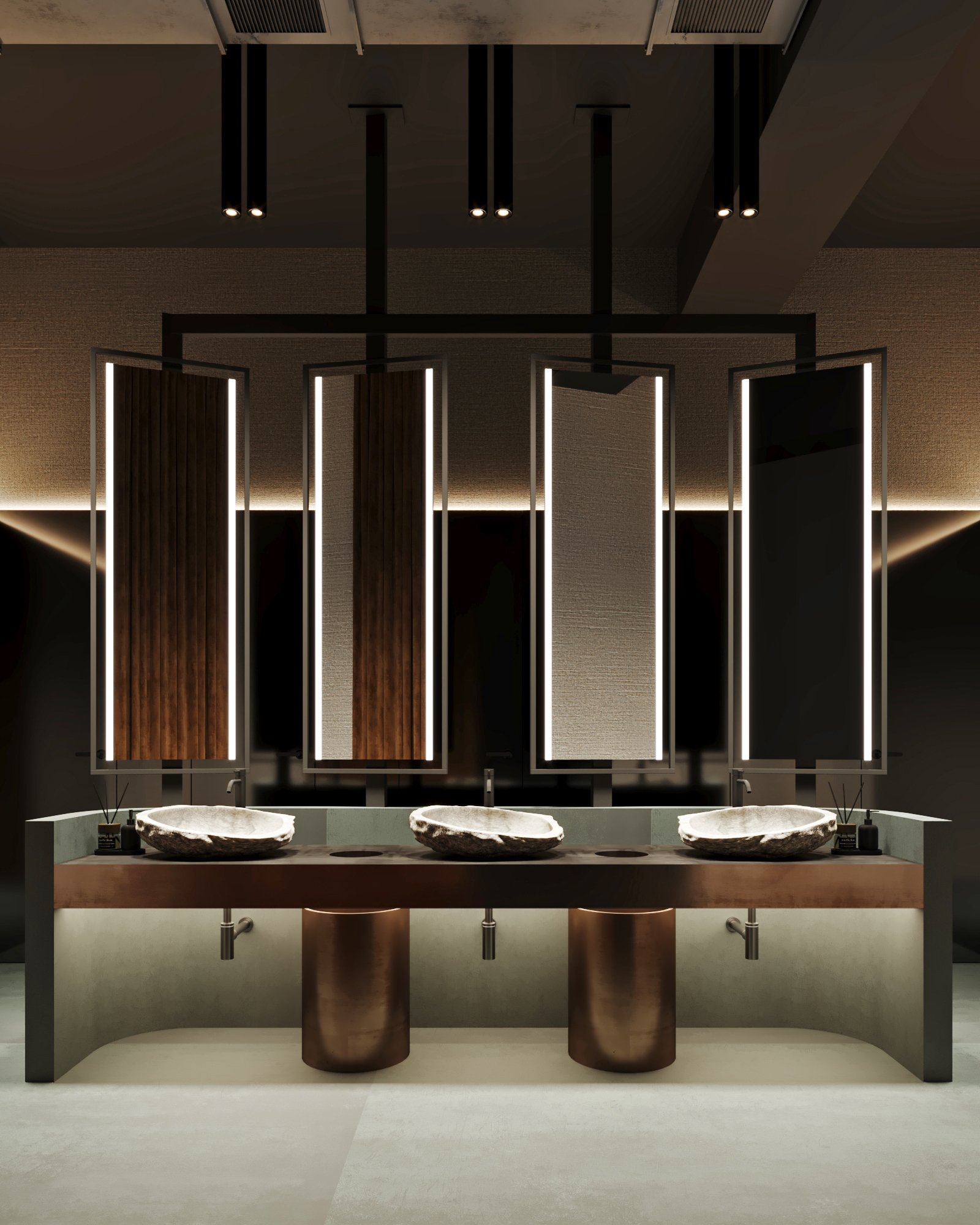 Luxury restroom featuring sculptural stone vessel sinks, bronze fixtures, and dramatic vertical lighting panels with textured wall treatments.