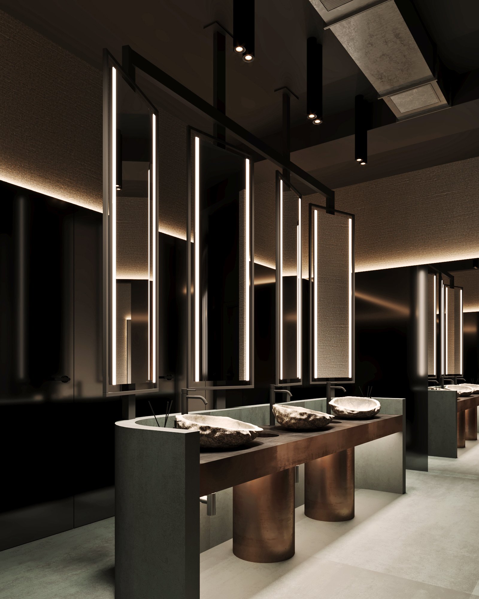 Detailed view of restroom vanity with custom stone basins, architectural lighting features, and bronze cylindrical supports.