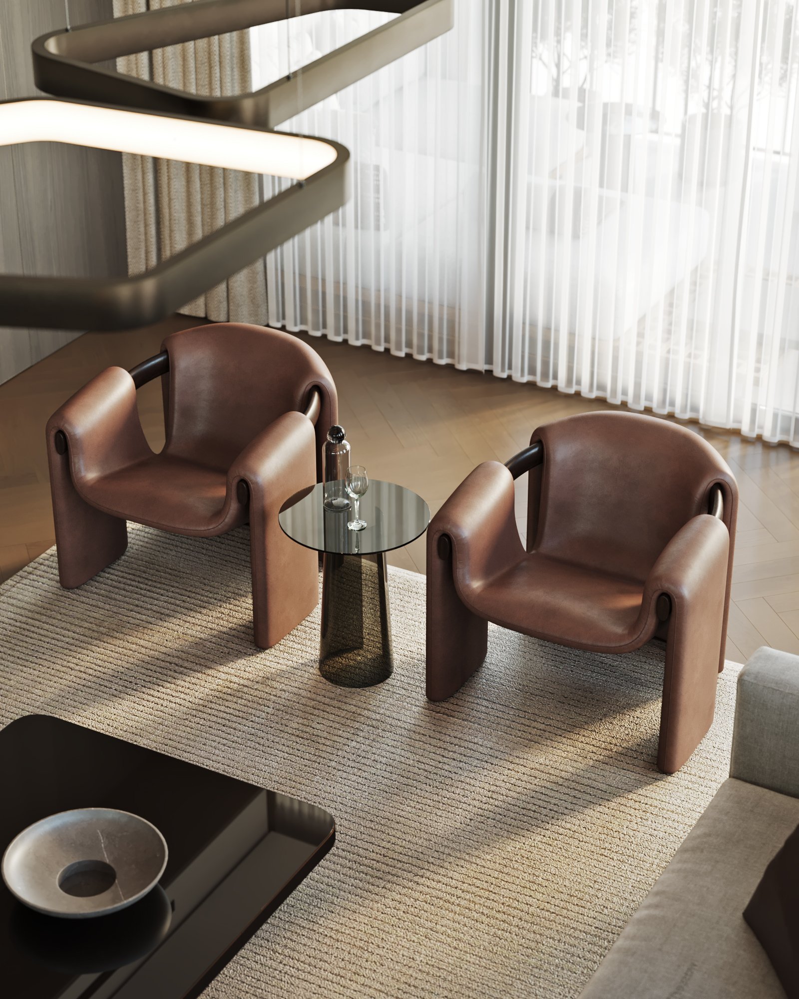 Detail of brown leather armchairs with sculptural design and glass side table in living area.